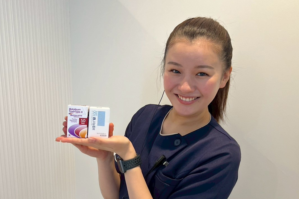 スタッフがボトックス製剤の箱を手に持ち、施術で使用する薬剤を紹介している様子。エラボトックスの説明イメージとして使われる写真