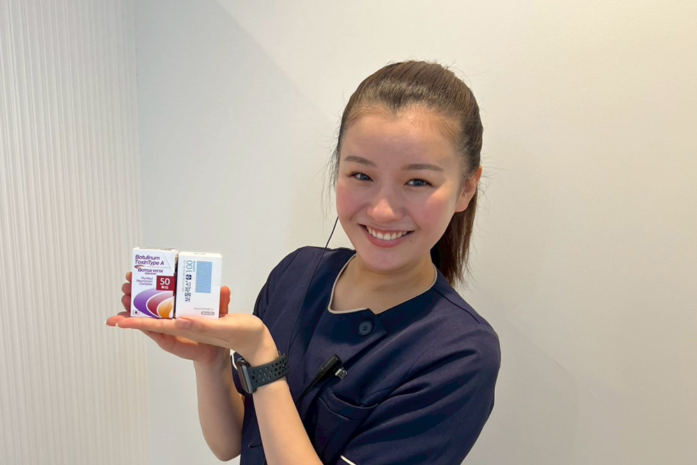 スタッフが脇ボトックスに使用する薬剤を手に持ち、笑顔で紹介しているイメージ写真